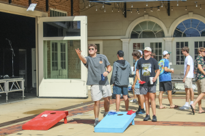 students at event play cornhole