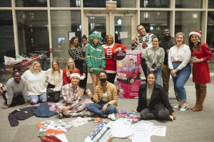 students, staff and partners gather for a group photo at gift-wrapping party