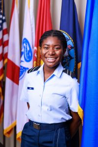 UA student Jahnaya poses in front of flags in her Air Force/ROTC uniform