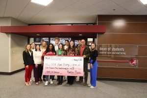 a group of people hold a large check dedicated to beat auburn beat hunger