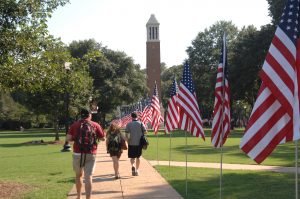 students walking by a row of american flags